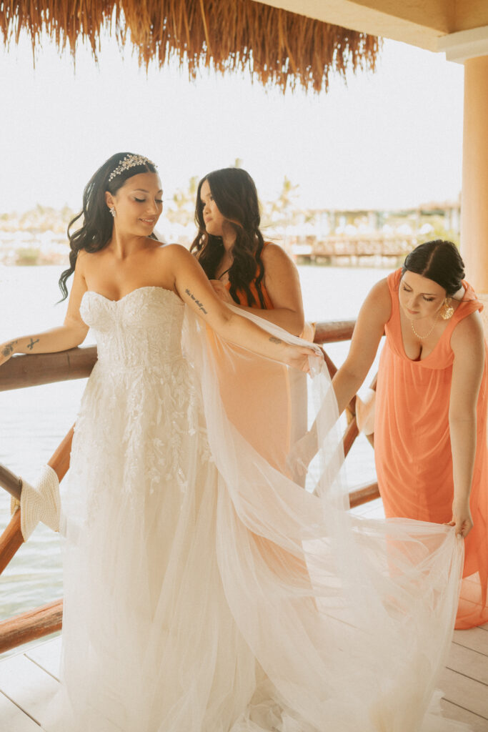 bridesmaid helping bride with her dress