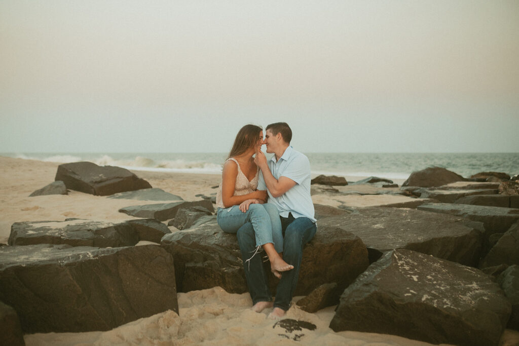 Cape May New Jersey beach engagement photos couple sitting on rock